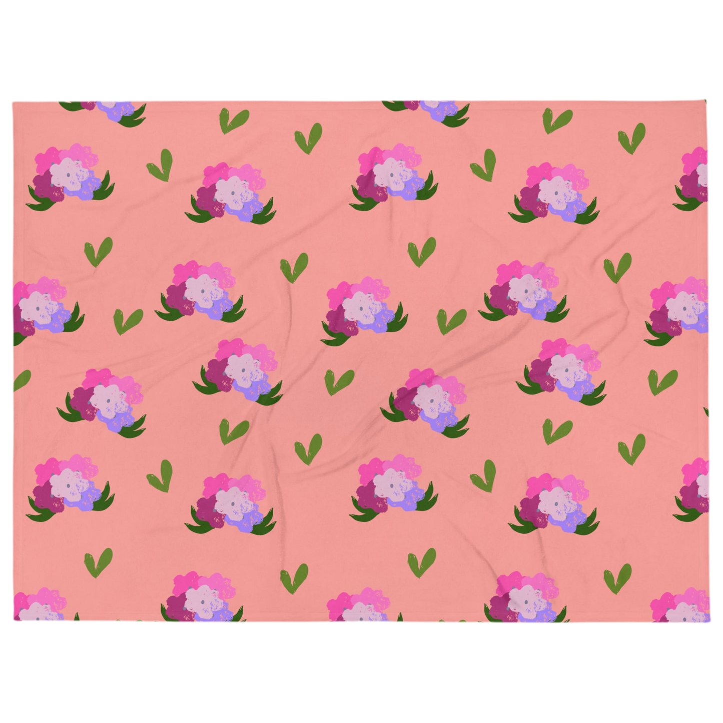 A photo of a soft pink blanket adorned with hand-drawn green leaves and bouquets of flowers in shades of pink and purple.