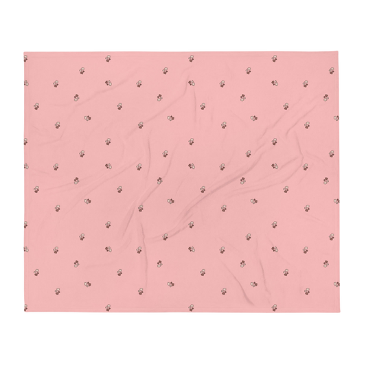 A photo of a pale pink blanket patterned with bunches of little flowers in neutral brown tones. 