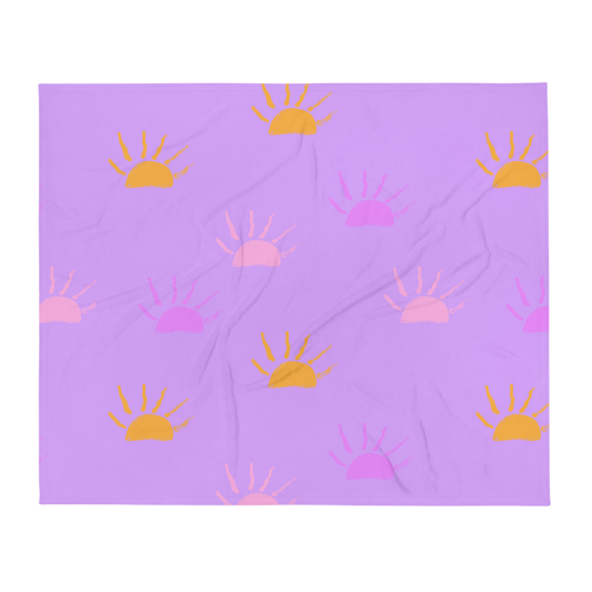 A photo of a purple blanket featuring hand-drawn sunsets in pink, purple and orange. 