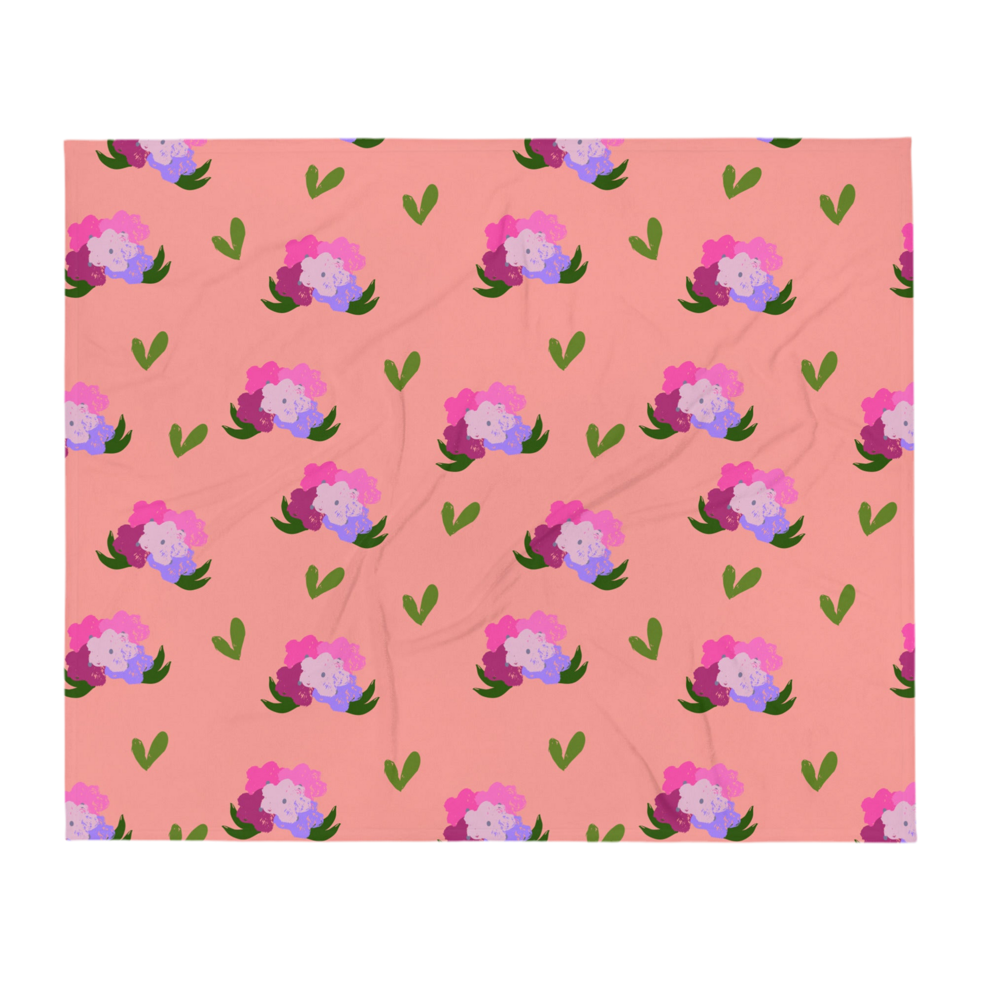 A photo of a soft pink blanket adorned with hand-drawn green leaves and bouquets of flowers in shades of pink and purple.