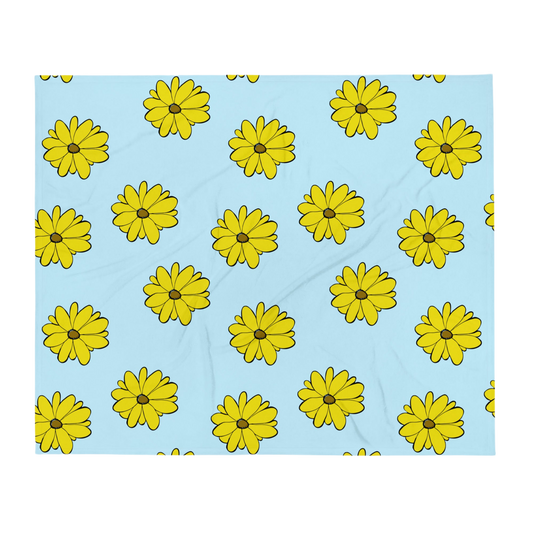 A photo of a blue blanket with a pattern of vibrant yellow sunflowers with brown centres.