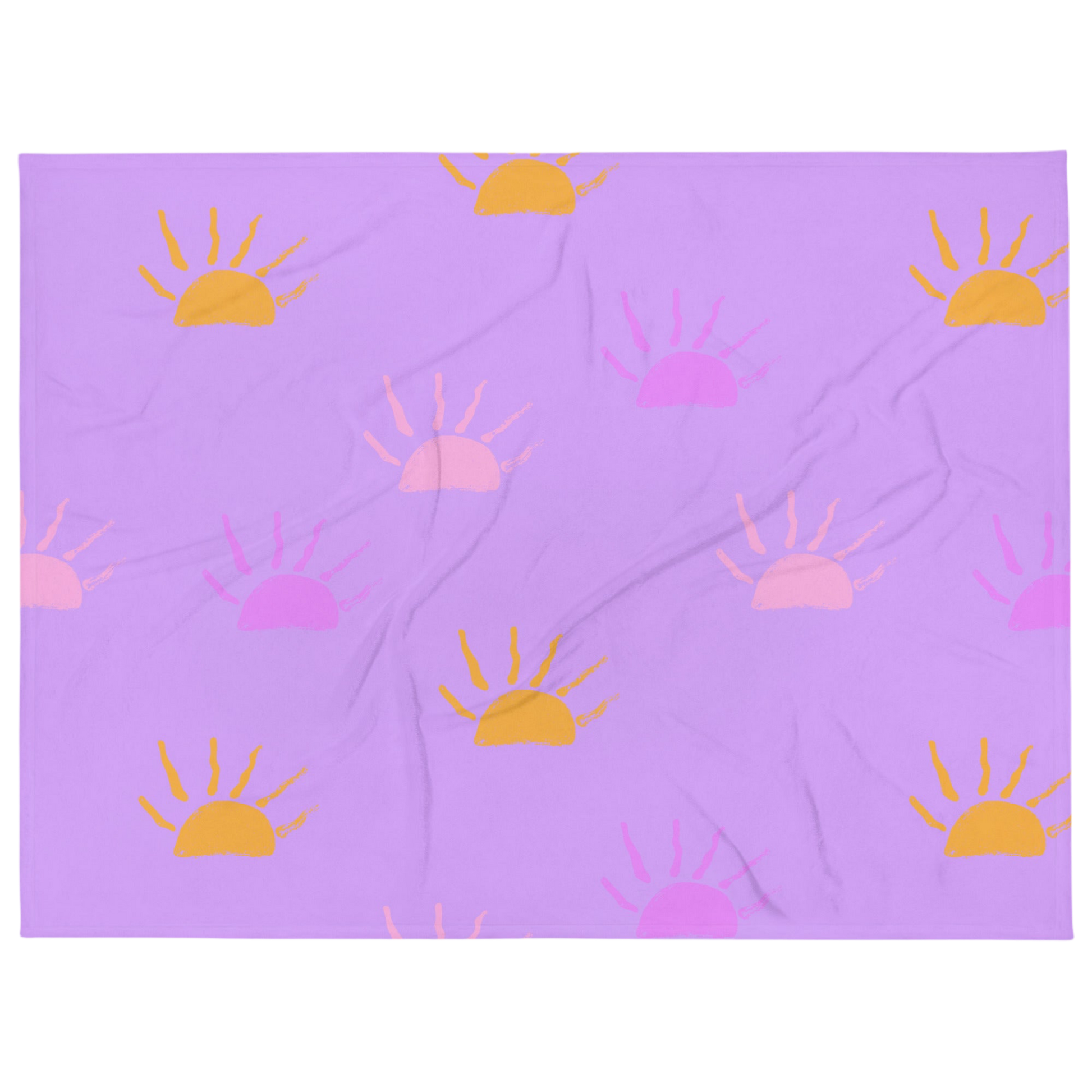 A photo of a purple blanket featuring hand-drawn sunsets in pink, purple and orange. 